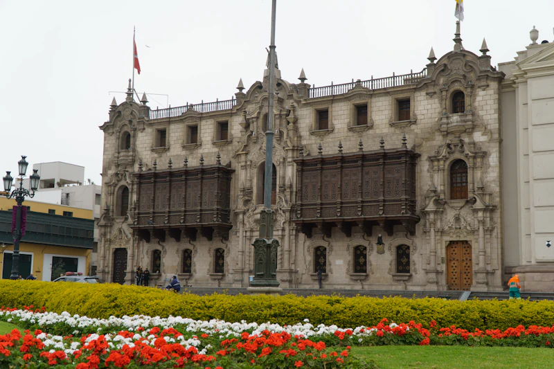Ornate building with flags and flower garden